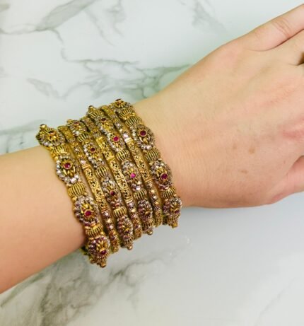 uxury gold-plated bangle set featuring maroon stone embellishments and delicate ball detailing