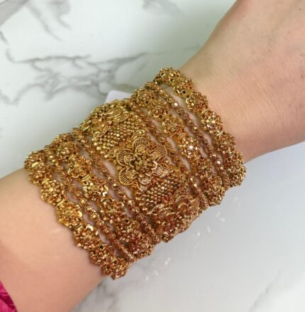 Elegant gold-plated bangle set with classic floral detailing, displayed on a woman's wrist for a traditional yet graceful look.