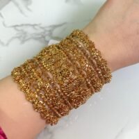Elegant gold-plated bangle set with classic floral detailing, displayed on a woman's wrist for a traditional yet graceful look.