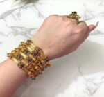 Traditional gold-plated bangles set with embedded stones and intricate detailing