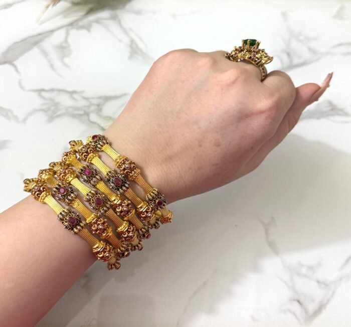 Traditional gold-plated bangles set with embedded stones and intricate detailing