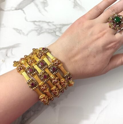 Traditional gold-plated bangles set with embedded stones and intricate detailing