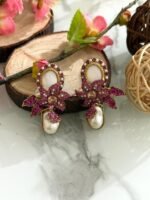 Gold loop earrings adorned with pink crystals, floral motif, and a pearl drop.