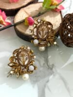 Ornate antique gold earrings with floral and leaf design, white stones, and hanging pearl drop.