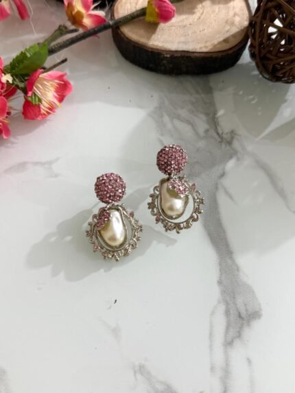 Ornate antique gold earrings with floral and leaf design, white stones, and hanging pearl drop.