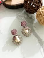 Ornate antique gold earrings with floral and leaf design, white stones, and hanging pearl drop.