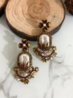 Step into elegance with these Baroque-inspired pearl drop earrings. Featuring a sculpted floral top and ornate golden detailing. Each piece is centered around a lustrous faux pearl with gem-studded accents. Delicate yet bold — perfect for ethnic wear or evening glam. Crafted to capture timeless grace with a garden-fantasy twist.