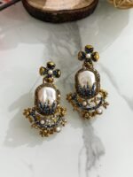 Step into elegance with these Baroque-inspired pearl drop earrings. Featuring a sculpted floral top and ornate golden detailing. Each piece is centered around a lustrous faux pearl with gem-studded accents. Delicate yet bold — perfect for ethnic wear or evening glam. Crafted to capture timeless grace with a garden-fantasy twist.