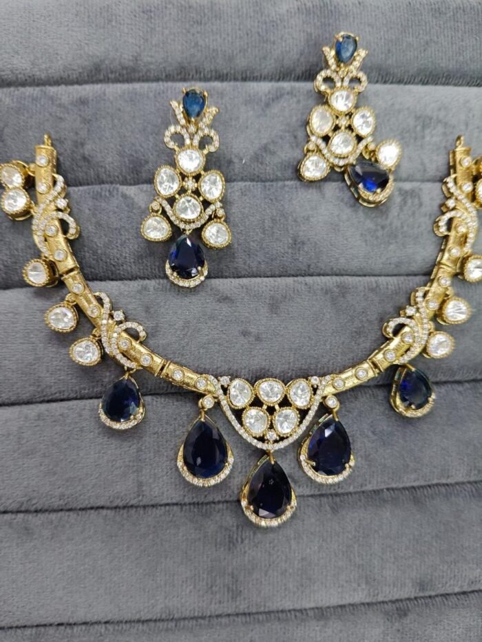 A traditional gold-tone kundan necklace with teardrop-shaped green emerald stones and shimmering white kundan detailing, worn with an ivory outfit.