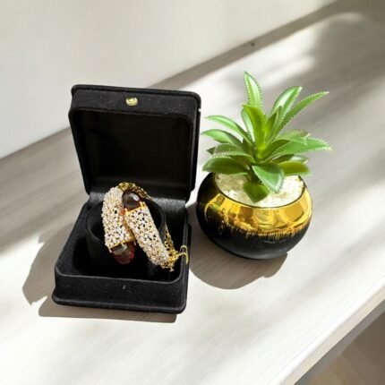 Gold bracelet with red stones and sparkling crystal embellishments.