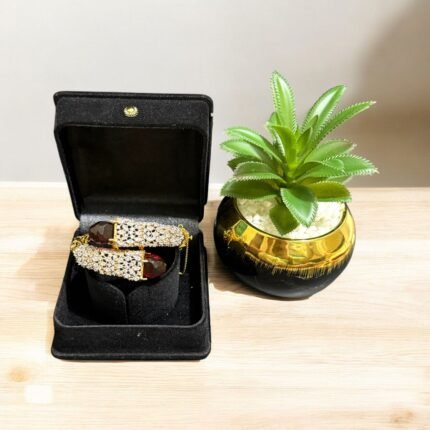 Gold bracelet with red stones and sparkling crystal embellishments.