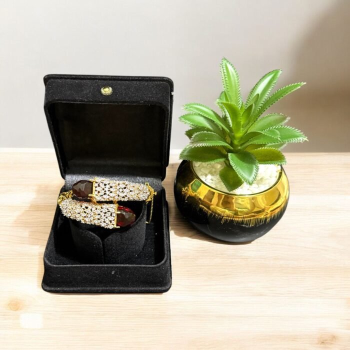 Gold bracelet with red stones and sparkling crystal embellishments.