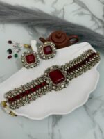 Traditional ruby red stone choker set with matching earrings placed on a white seashell-shaped tray.
