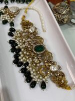 Traditional bridal choker jewelry set with green beads, pearl drops, and matching earrings and maang tikka displayed in a white tray.