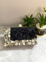 A stylish black clutch with sparkling crystal and mother-of-pearl embellishments, perfect for adding elegance to formal occasions and special events.