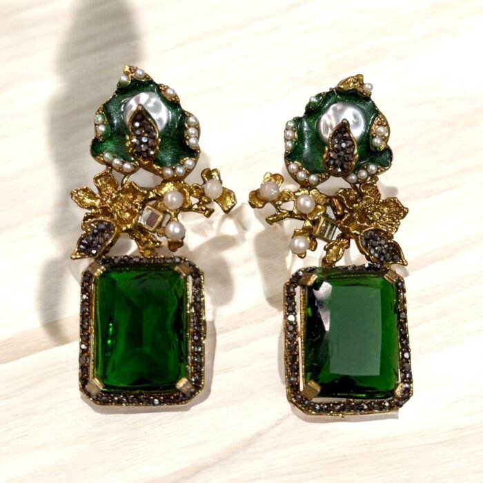 A green and gold necklace set with pearl and crystal embellishments, including matching earrings, displayed on a white surface.
