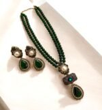 Emerald green necklace and earring set with pearl and crystal accents, displayed on a light-colored background.
