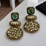 Vintage-style gold earrings with blue and pearl accents, featuring geometric-shaped stones.