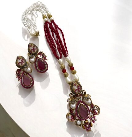 Ruby and pearl embellished necklace set with matching earrings, featuring gold detailing.