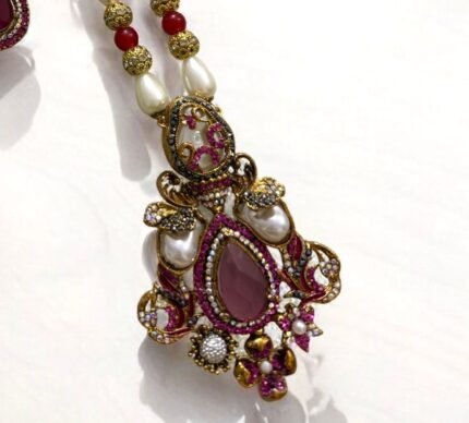 Ruby and pearl embellished necklace set with matching earrings, featuring gold detailing.