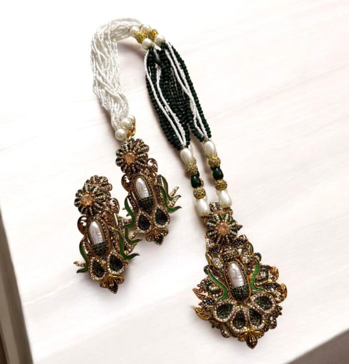 Elegant black gemstone and pearl necklace set with gold-tone accents, including matching earrings with a floral design.