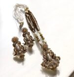 Elegant black gemstone and pearl necklace set with gold-tone accents, including matching earrings with a floral design.