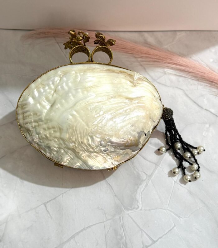 Black and gold vintage evening clutch with pearls, crystals, and a bird-shaped top handle, accompanied by a pearl tassel.