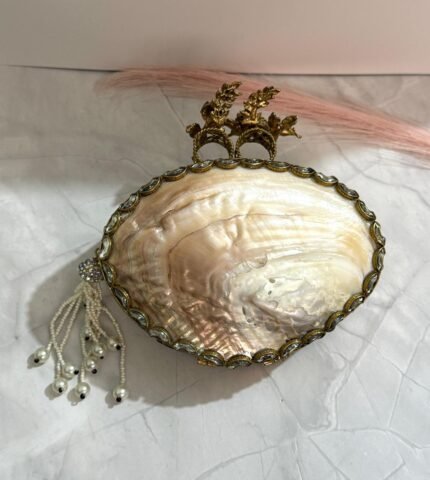 Black and gold floral evening clutch with pearl embellishments and a tassel detail, featuring bird-shaped top handles.