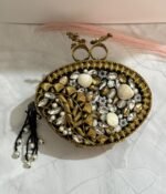 Black and gold vintage evening clutch with pearls, crystals, and a bird-shaped top handle, accompanied by a pearl tassel.
