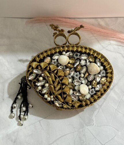 Black and gold vintage evening clutch with pearls, crystals, and a bird-shaped top handle, accompanied by a pearl tassel.