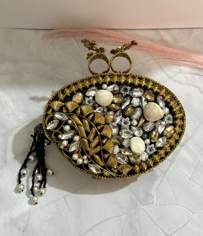 Black and gold vintage evening clutch with pearls, crystals, and a bird-shaped top handle, accompanied by a pearl tassel.