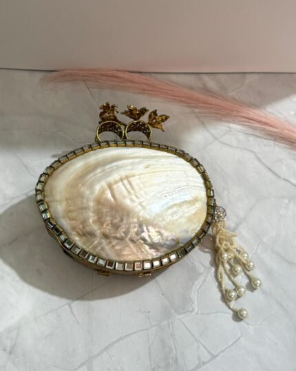 Vintage-inspired evening clutch with clear and gold-toned crystals, pearls, floral design, and a tassel detail.