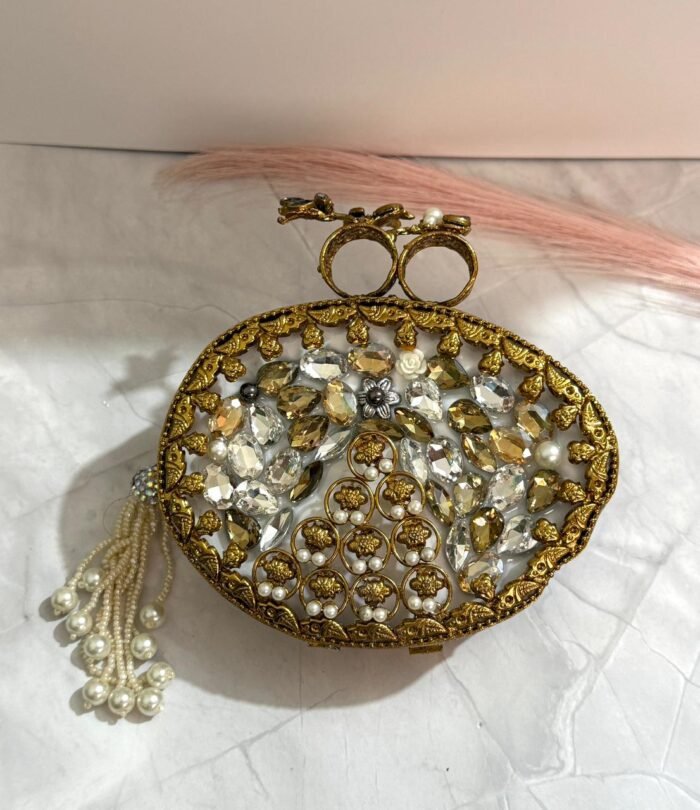 Vintage-inspired evening clutch with clear and gold-toned crystals, pearls, floral design, and a tassel detail.