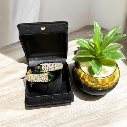 Gold bracelet with green stones and sparkling crystal embellishments.