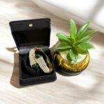 Gold bracelet with green stones and sparkling crystal embellishments.