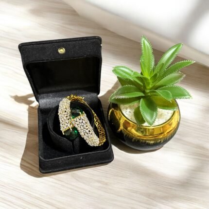 Gold bracelet with green stones and sparkling crystal embellishments.