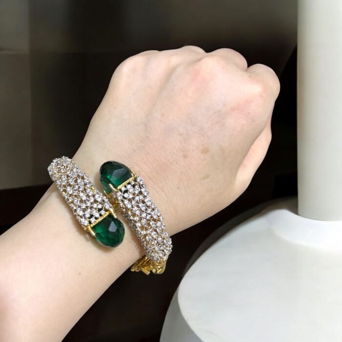 Gold bracelet with green stones and sparkling crystal embellishments.