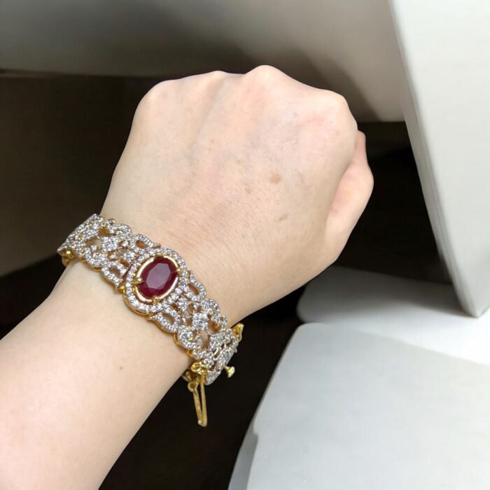 Gold bracelet with a ruby center stone and crystal accents.
