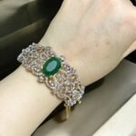 Chic bracelet with a green stone centerpiece and dazzling crystal accents, perfect for adding a luxurious touch to any outfit.