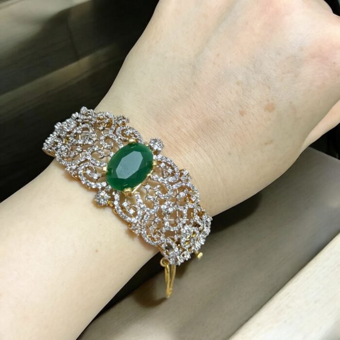 Chic bracelet with a green stone centerpiece and dazzling crystal accents, perfect for adding a luxurious touch to any outfit.
