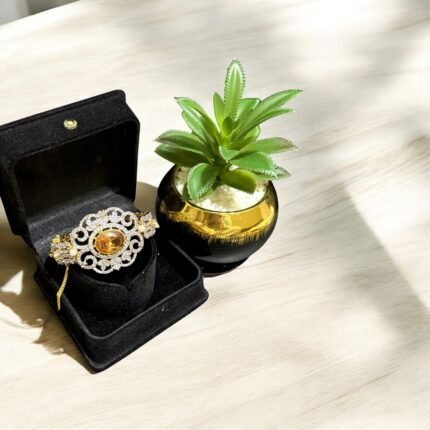 Gold bracelet with citrine center stone, crystal embellishments, and pearl accents.