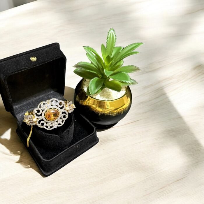 Gold bracelet with citrine center stone, crystal embellishments, and pearl accents.