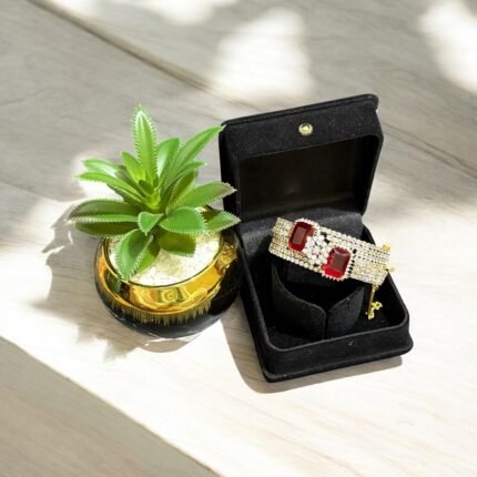 Gold bracelet with red stones and crystal embellishments.
