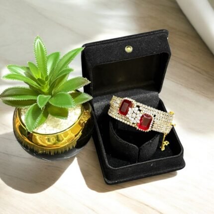 Gold bracelet with red stones and crystal embellishments.