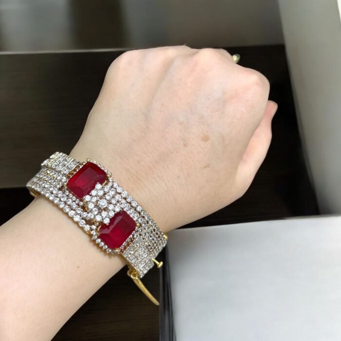 Gold bracelet with red stones and crystal embellishments.