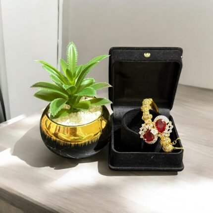 Gold bracelet with red teardrop stones and crystal embellishments.