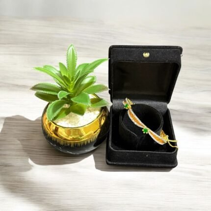 Gold bracelet with green stones and sparkling crystal accents.