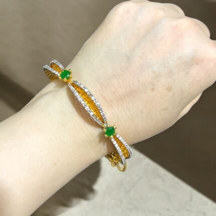 Gold bracelet with green stones and sparkling crystal accents.
