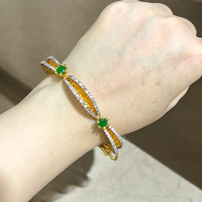Gold bracelet with green stones and sparkling crystal accents.