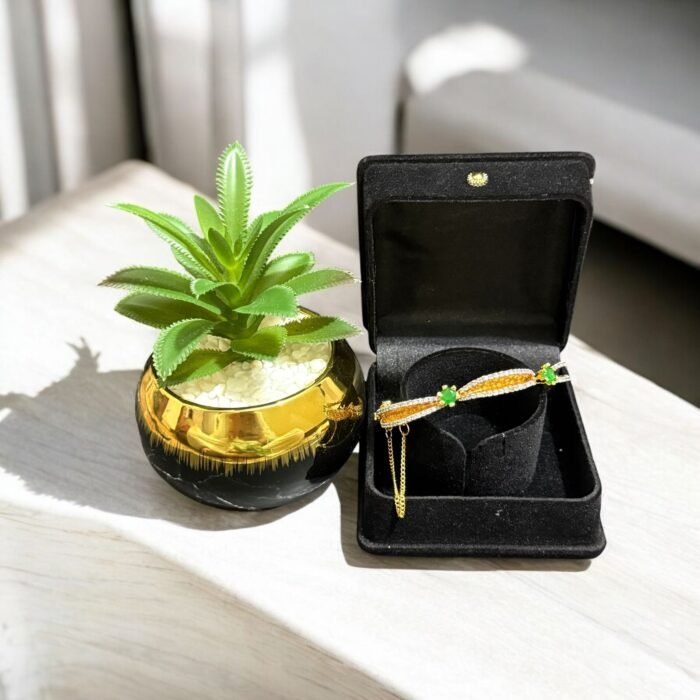 Gold bracelet with green stones and sparkling crystal accents.